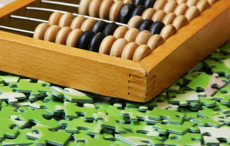 wooden abacus on pile of green puzzleの写真素材