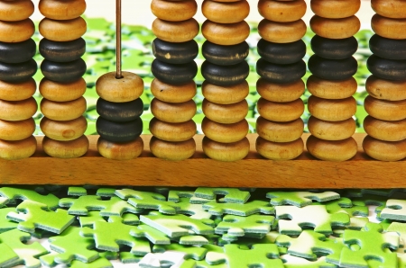 wooden abacus on pile of green puzzleの写真素材