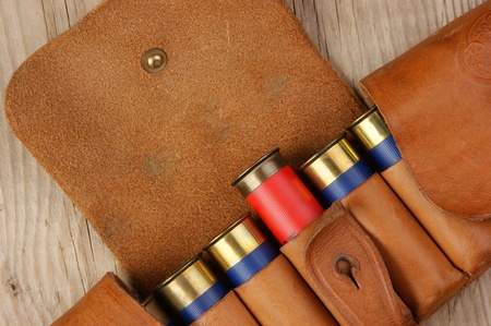 Old hunting cartridges and bandoleer on a wooden table