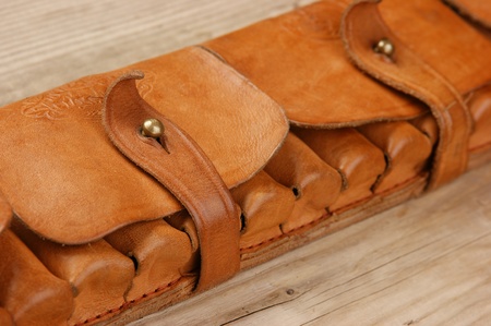 Old hunting cartridges and bandoleer on a wooden tableの写真素材