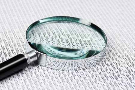 magnifying glass on the background of a binary codeの写真素材