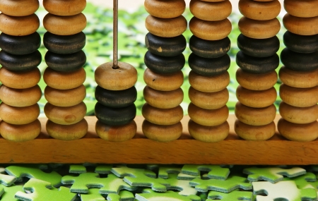 wooden abacus on pile of green puzzleの写真素材
