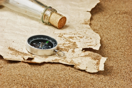 compass and old torn paper on a sandy beachの写真素材