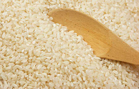 raw rice and wooden spoonの写真素材