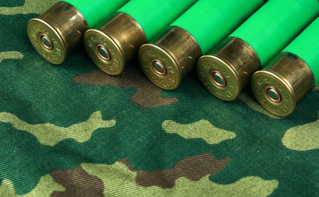 Old hunting cartridges on camouflage background