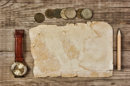 Old paper and coins on a wooden tableの写真素材