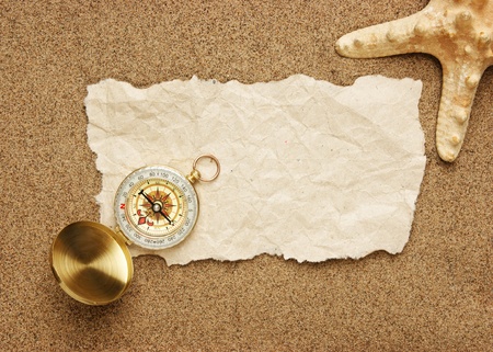 compass and old torn paper on a sandy beachの写真素材