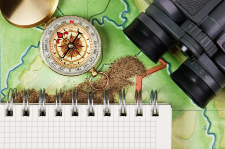 binoculars and a compass on the map with sandの写真素材