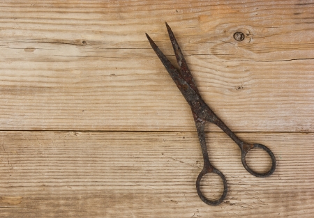 old rusty scissors on the wooden background
