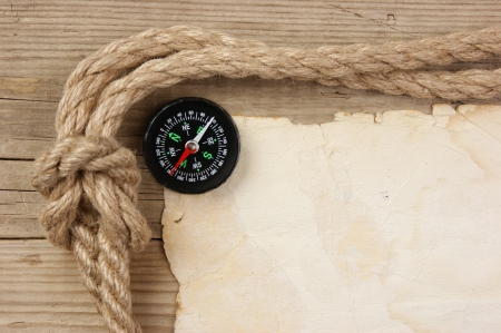 Vintage paper with compass and rope on old wooden boardsの写真素材