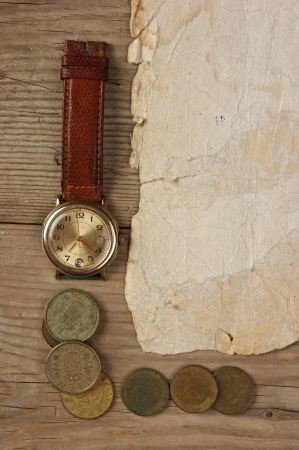 Old paper and coins on a wooden tableの写真素材