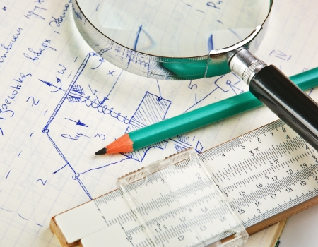 magnifying glass and a slide rule on the old page with the calculations in mechanicsの写真素材