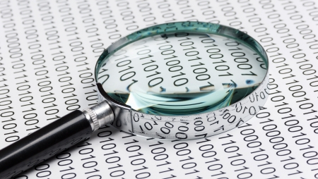 magnifying glass on the background of a binary codeの写真素材