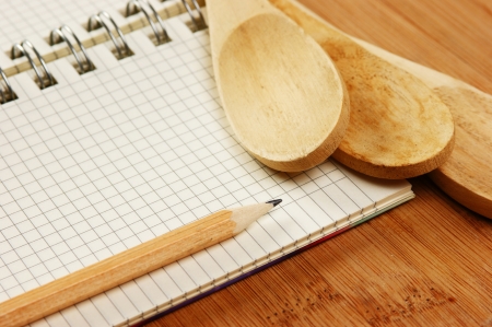 notebook for culinary recipes on a kitchen cutting boardの写真素材