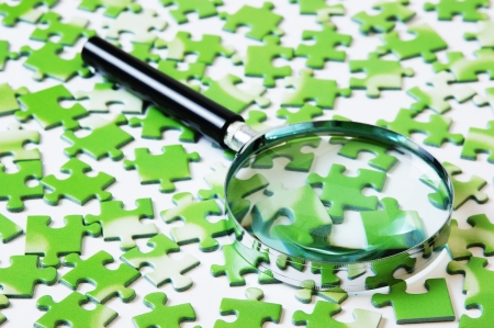 magnifying glass on the green puzzleの写真素材