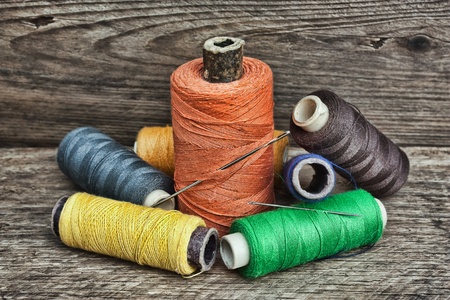 still life of spools of thread on a wooden background