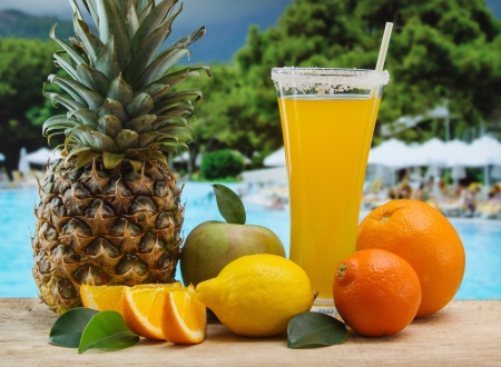 Glass of orange juice on a beach table の写真素材