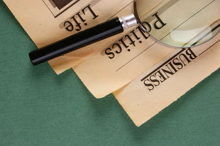old newspaper and magnifying glass on a green backgroundの写真素材