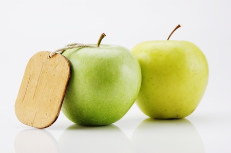 two green apple with tag isolated on white backgroundの写真素材
