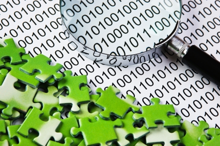 puzzles and magnifying glass on a binary codeの写真素材
