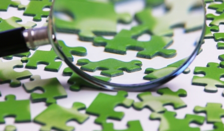 magnifying glass on the green puzzleの写真素材