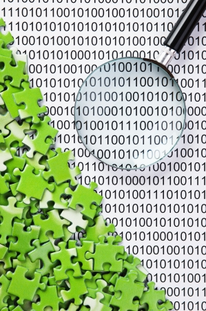 puzzles and magnifying glass on a binary codeの写真素材