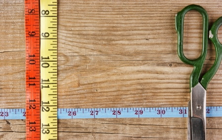 sartorial meter and scissors on the old wooden backgroundの写真素材