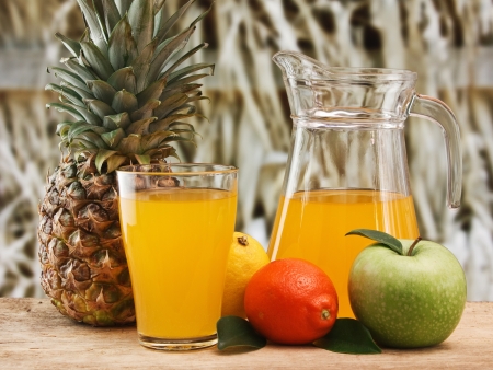 variety of fruit and juice on a wooden table in the gardenの写真素材