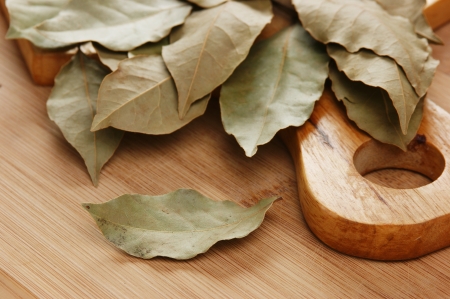 dry bay leaf on a wooden kitchen cutting boardの写真素材