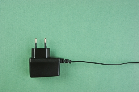 black charger adapter with plug on the green backgroundの写真素材