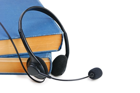 Headphones with a microphone and a stack of books isolated on white backgroundの写真素材