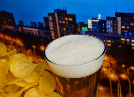 glass of beer and potato chips in a landscapeの写真素材