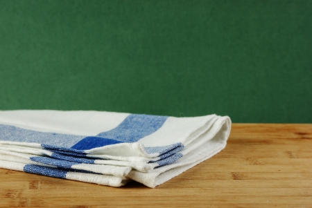 Table-napkin and old wooden deck table with green grunge backgroundの写真素材