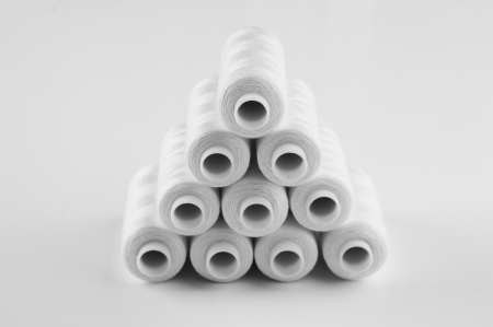 bobbin with white thread on a white backgroundの写真素材