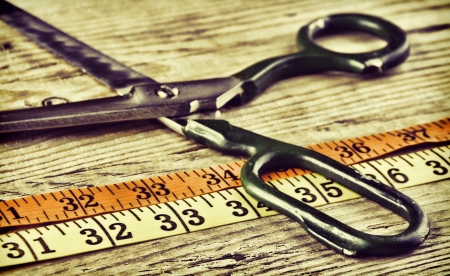 sartorial meter and scissors on the old wooden background