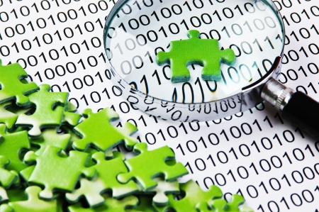 puzzles and magnifying glass on a binary codeの写真素材