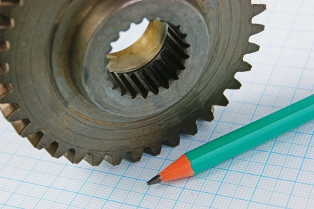 Gear and pencil on graph paperの写真素材