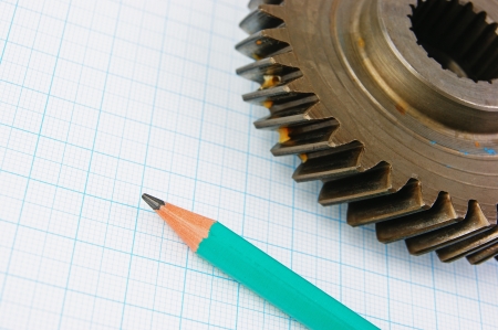 Gear and pencil on graph paperの写真素材