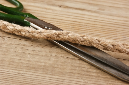 old tailor scissors and rope on the wooden background