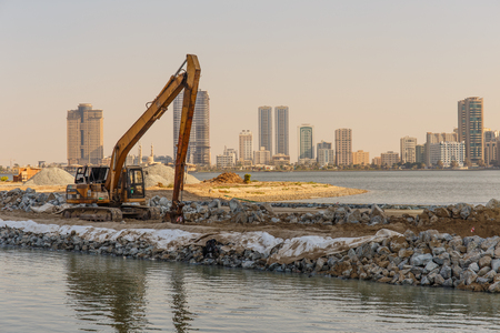 SHARJAH, UAE - OCTOBER 28, 2013: Excavator on a construction site. Sharjah is located along northern coast of Persian Gulf on Arabian Peninsulaのeditorial素材