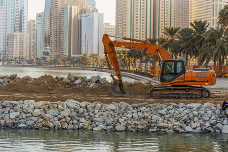 SHARJAH, UAE - OCTOBER 28, 2013: Excavator on a construction site. Sharjah is located along northern coast of Persian Gulf on Arabian Peninsulaのeditorial素材