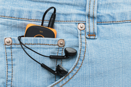 Player with headphones in the pocket of jeansの写真素材