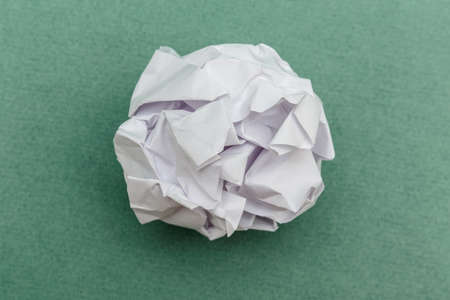 wad of crumpled paper on green background