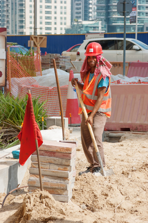 DUBAI, UAE - NOVEMBER 16: Worker on Road repair in Dubai Marina, on November 16, 2012, Dubai, UAE. Dubai was the fastest developing city in the world between 2002 and 2008.のeditorial素材