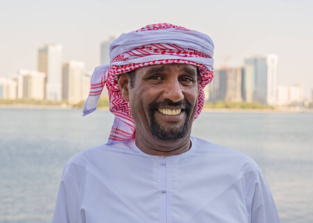 SHARJAH, UAE - OCTOBER 28, 2013: Portrait of an unknown Arab men on the waterfront in Sharjah, UAEのeditorial素材