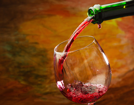 Red wine being poured into wine glassの写真素材