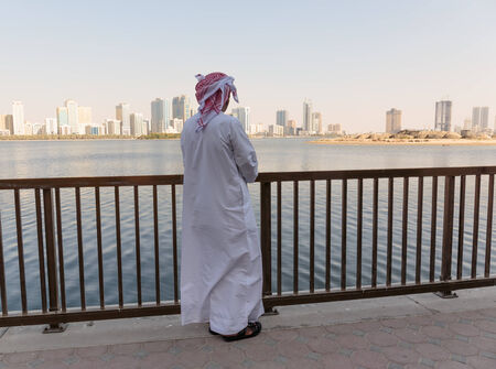 SHARJAH, UAE - OCTOER 28, 2013: Portrait of an unknown Arab men on the waterfront. Sharjah is located along northern coast of Persian Gulf on Arabian Peninsulaのeditorial素材
