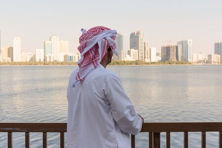 SHARJAH, UAE - OCTOER 28, 2013: Portrait of an unknown Arab men on the waterfront. Sharjah is located along northern coast of Persian Gulf on Arabian Peninsulaのeditorial素材