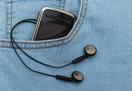 Player with headphones in the pocket of jeansの写真素材