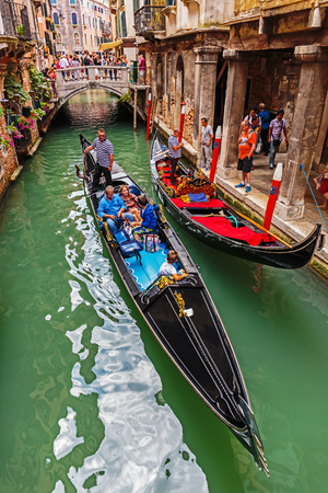 VENICE, ITALY - 26 JUNE, 2014: Gondolier rides gondola. The profession of gondolier is controlled by a guild, which issues a limited number of licensesのeditorial素材
